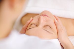 Close-up shot of a woman during the seance of facial massage in beauty spa
